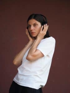 Pretty young woman with headphones listening to music though headset.
