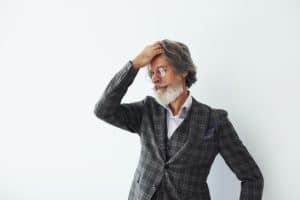 Senior stylish modern man with grey hair and beard indoors