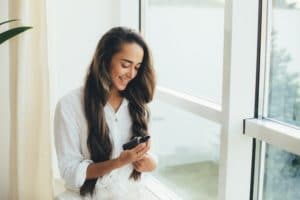 Woman applying natural organic essential oil on hair. Home spa beauty rituals.