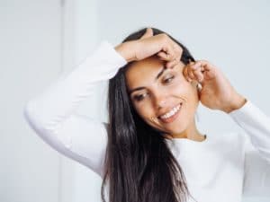 young beautiful brunette woman doing face massage to herself